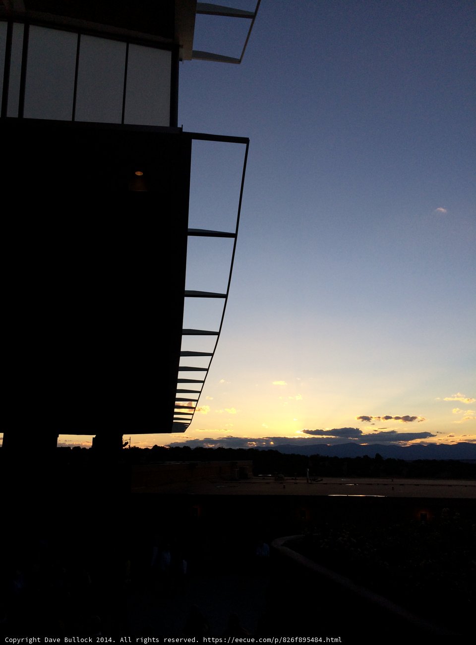 Sunset Silhouette of a Building with a Plane flying over