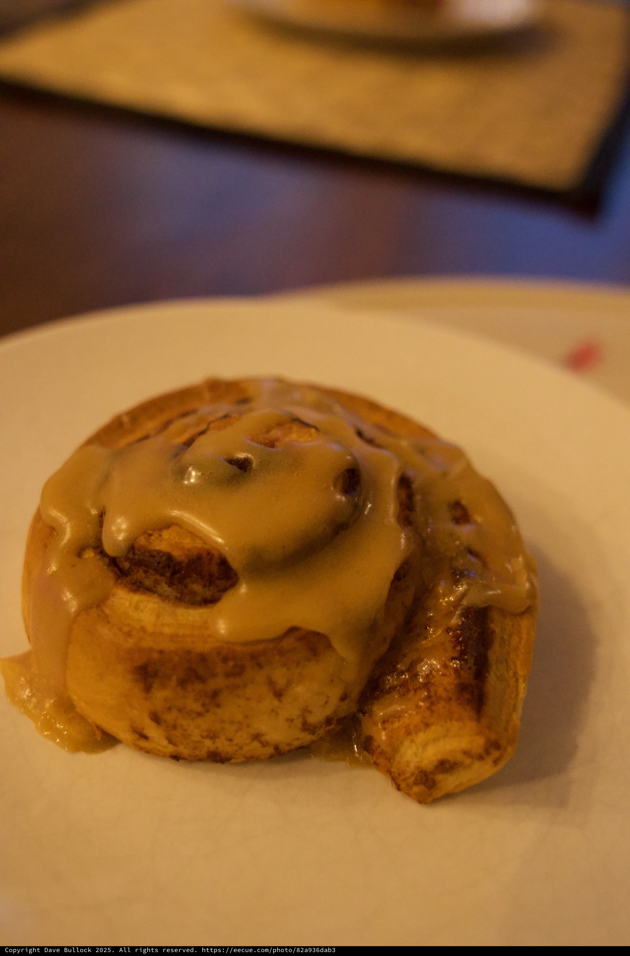 Glazed Cinnamon Roll with Icing on White Plate