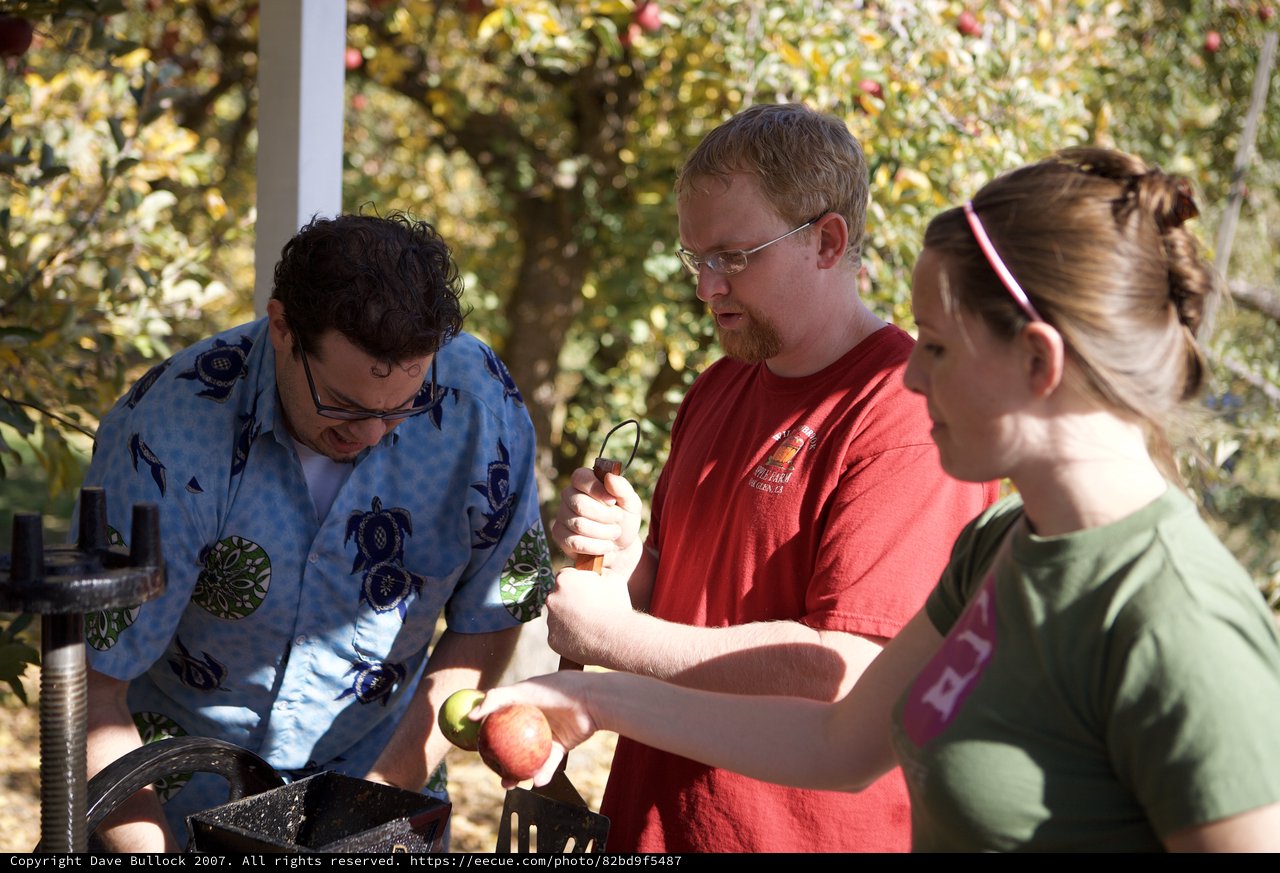 Friends Making Fresh Apple Cider at Autumn Orchard