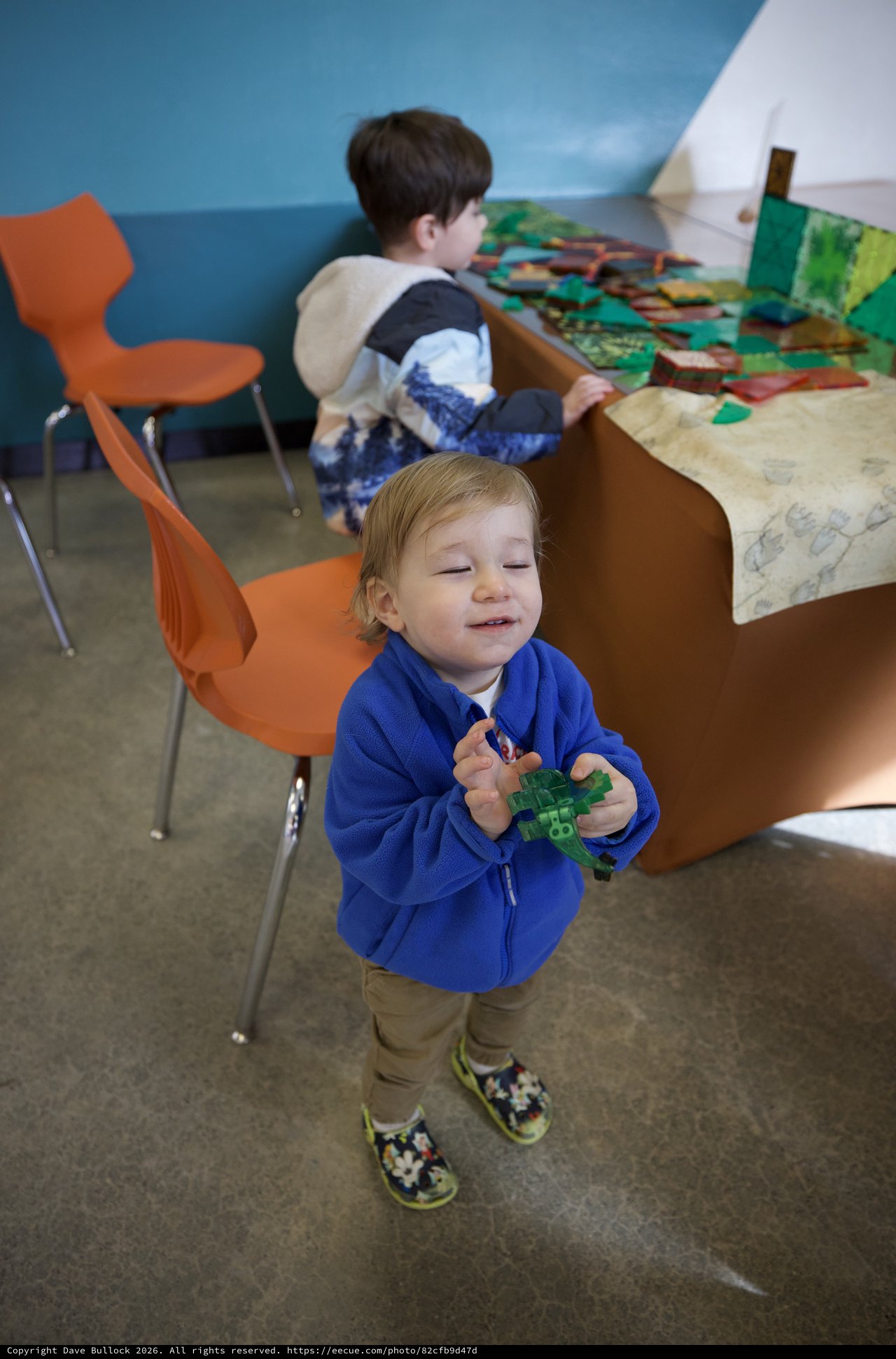 Young Child Playing with Green Toy in Classroom Setting