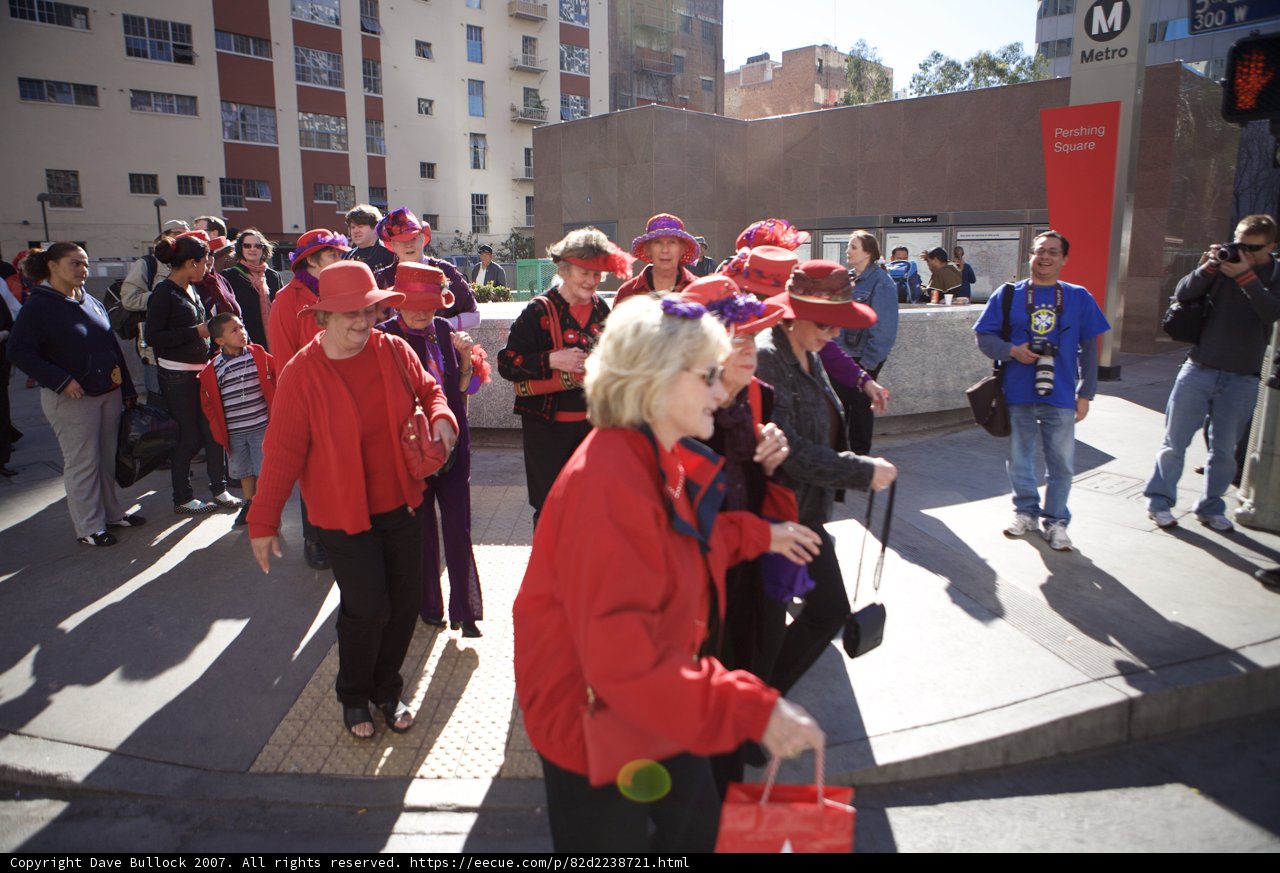 Women in Red Stride Down the Sidewalk