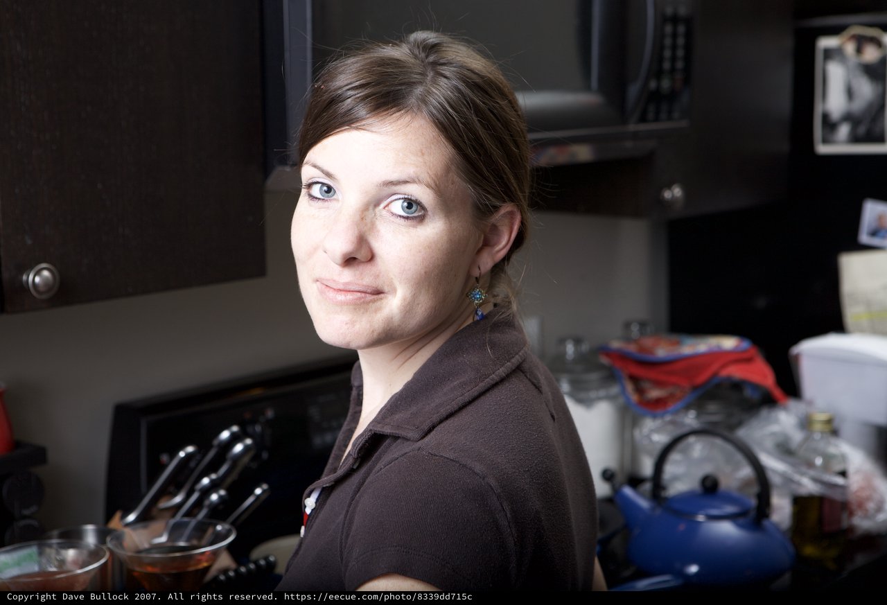 Woman in Kitchen Glances Over Her Shoulder