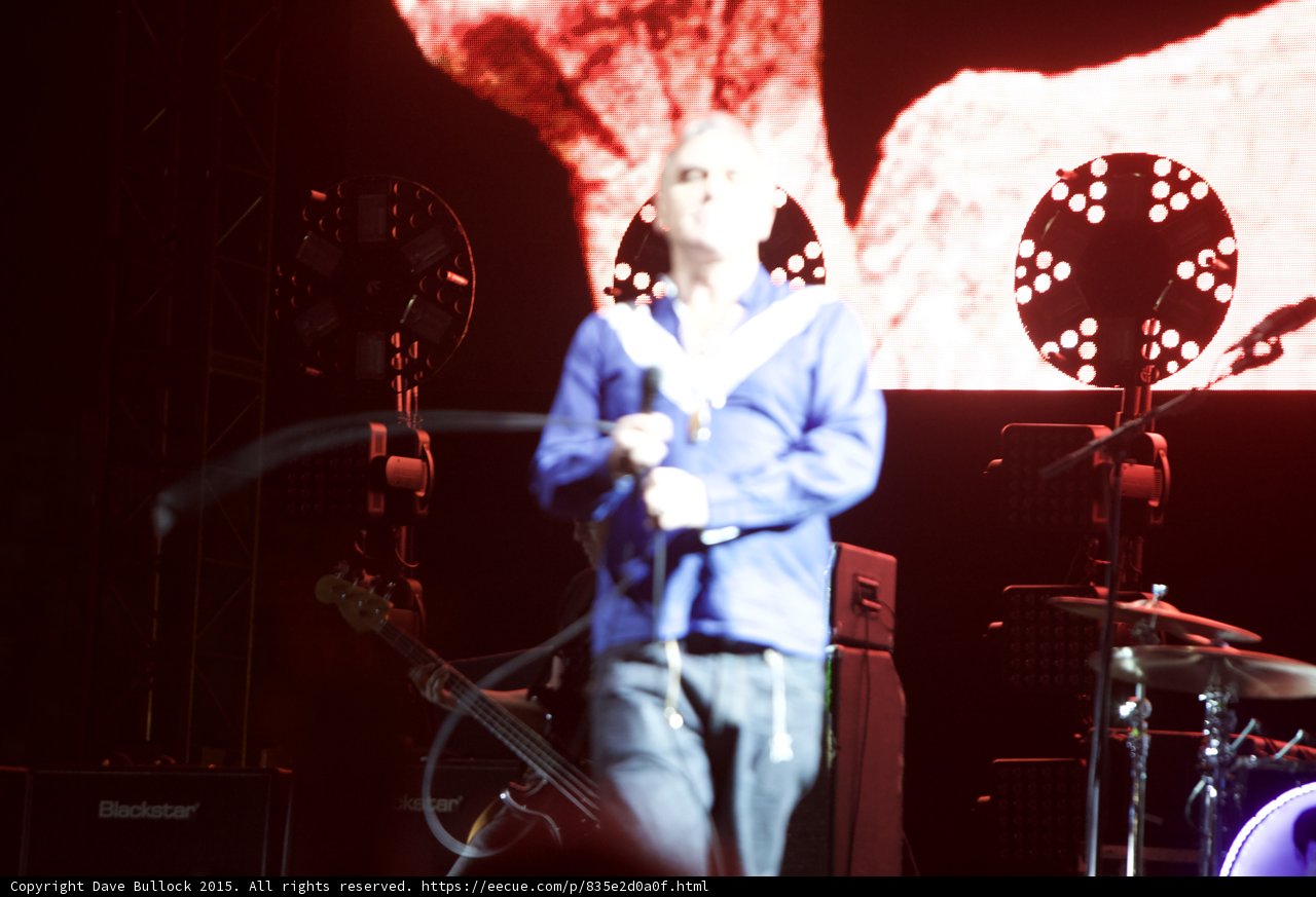 Morrissey Motion Blur Blue Shirt Bassist Two Circular Lights Blackstar Cymbals Red Screen