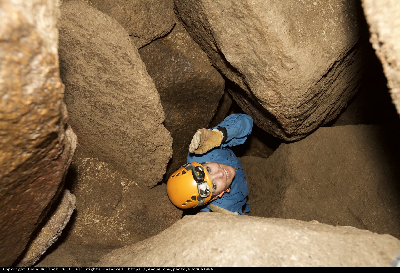 Caver Squeezes Through Tight Rocky Passage Underground
