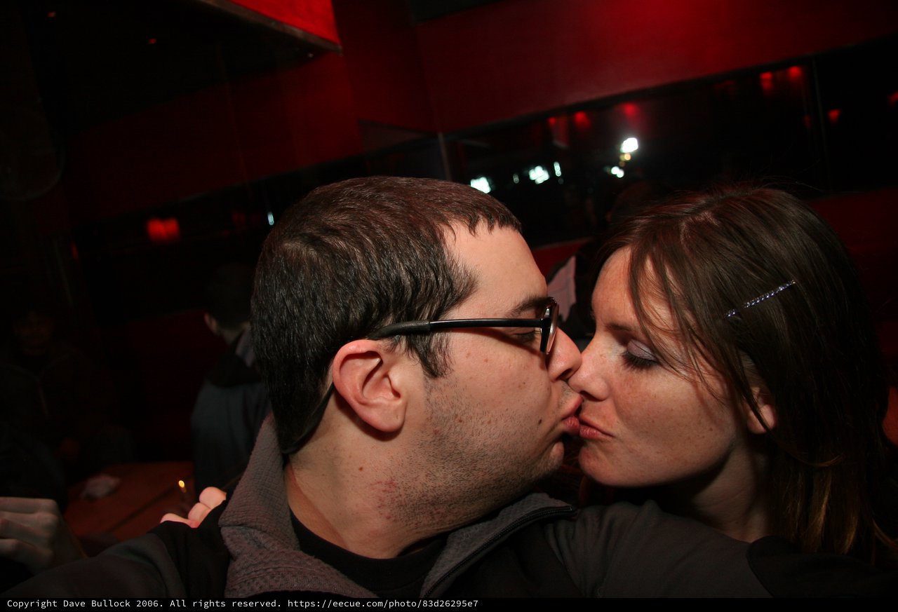 Couple Sharing a Kiss at Dimly Lit Nightclub
