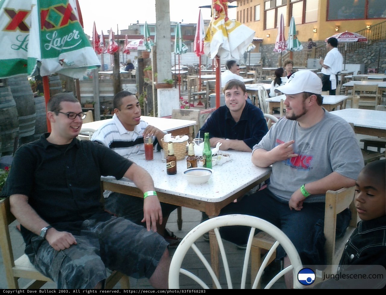 Four Men Enjoying Beer and Food at a Restaurant