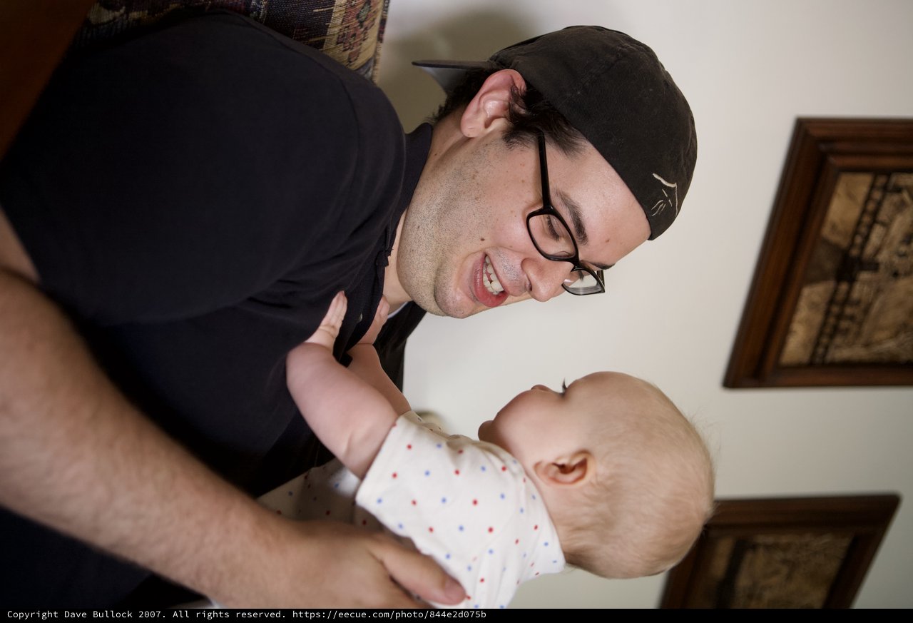 Joyful Man Bonding With Adorable Baby Indoors