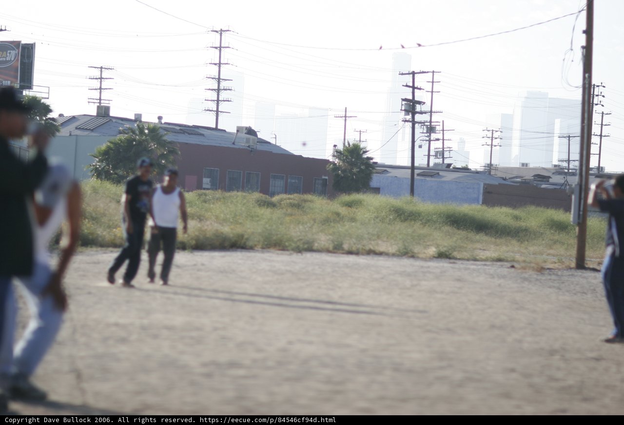 Group of 5 playing baseball in a dirt field