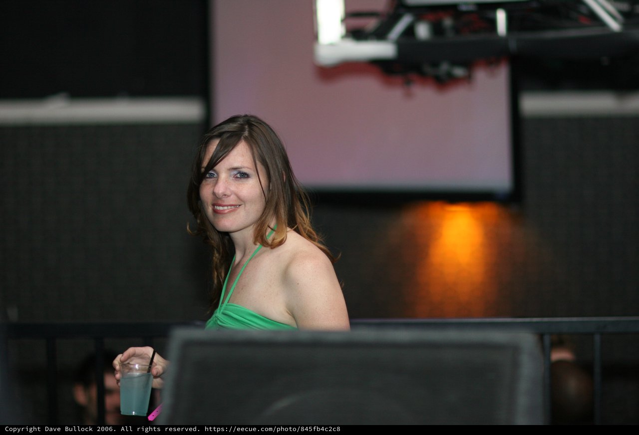 Smiling Woman in Green at Evening Social Event