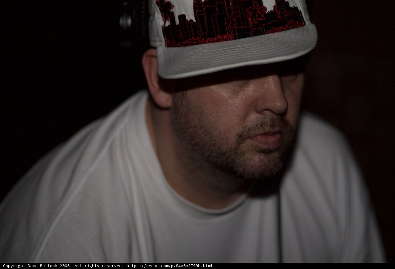 Hat-wearing man in a dark room