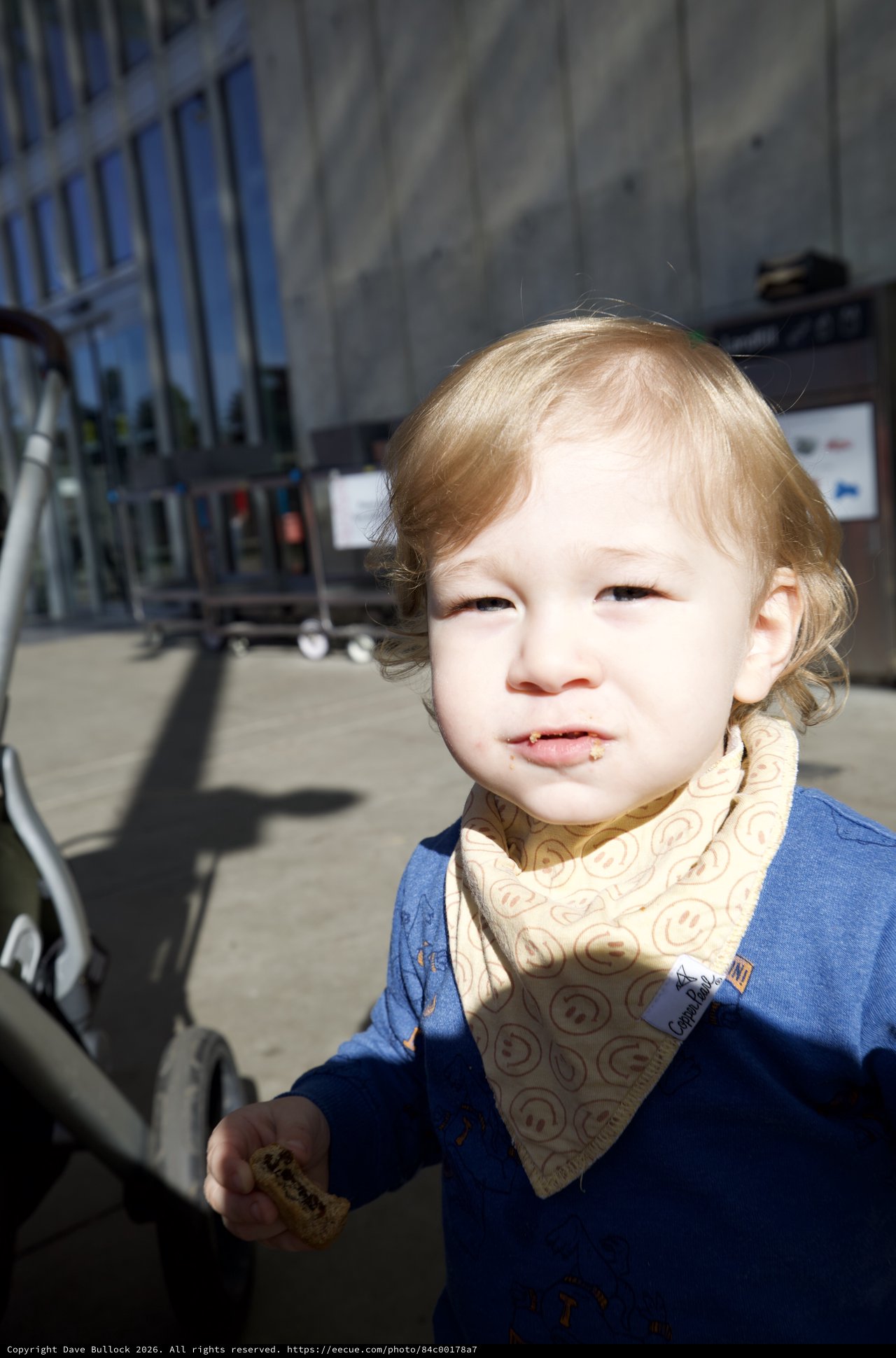 Toddler with Blonde Hair Enjoying Snack Outdoors