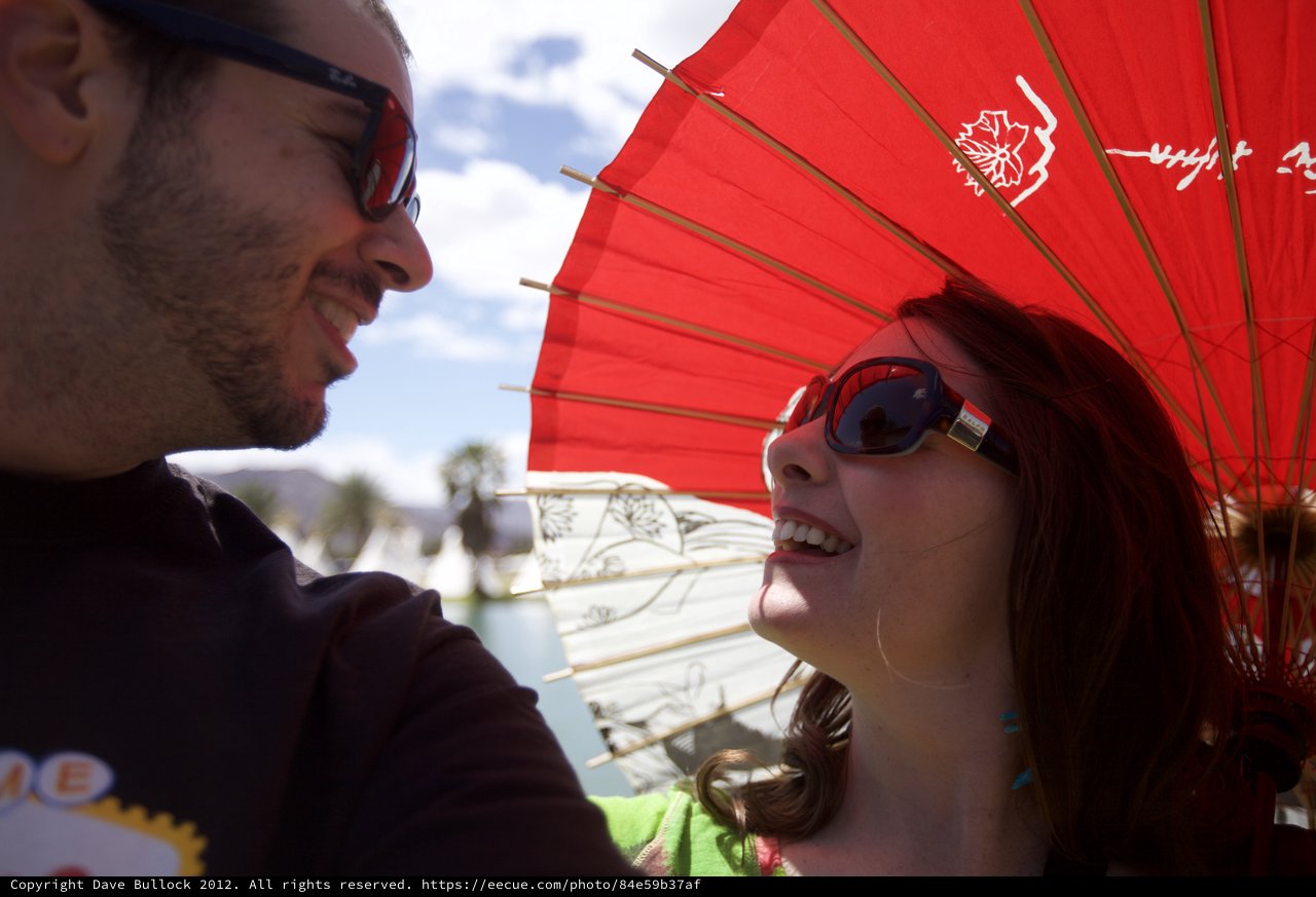Shared Laughter Under a Red Parasol at Coachella