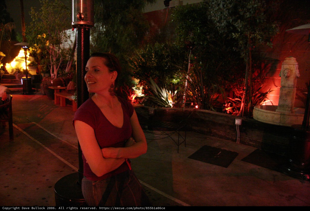 Woman Smiling by Patio Heater at Night