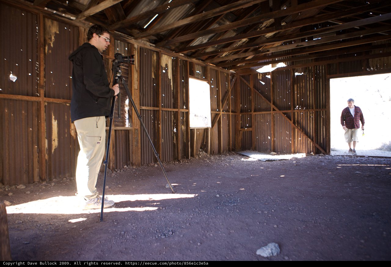 Photographer Documenting Abandoned Desert Structure Interior