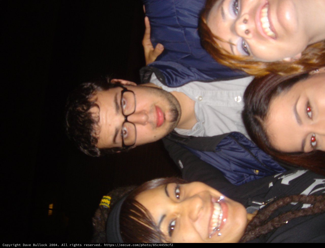 Four Friends Smiling Together on a Dark Night