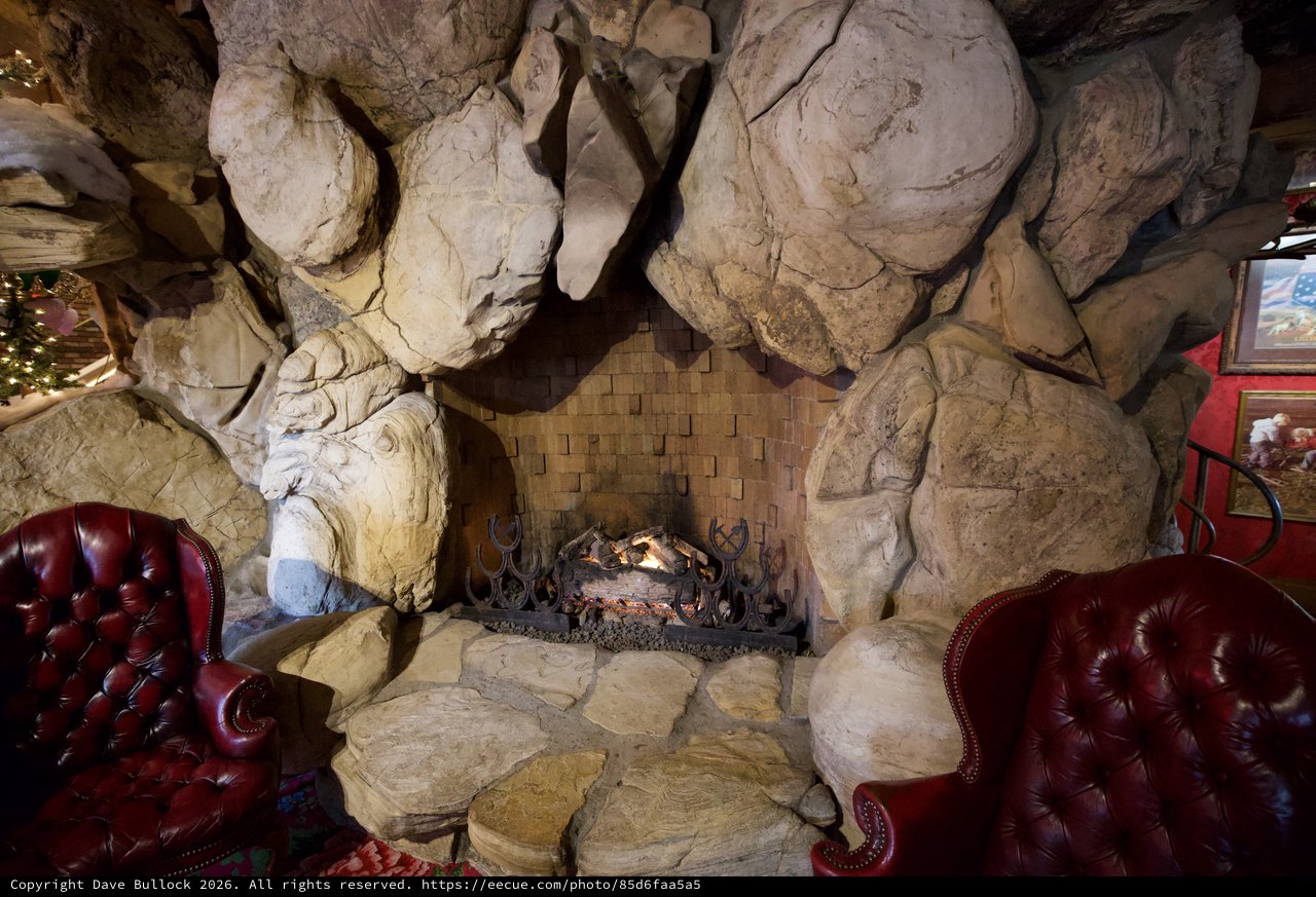 Rustic Stone Fireplace with Leather Armchairs in Cave-Like Interior