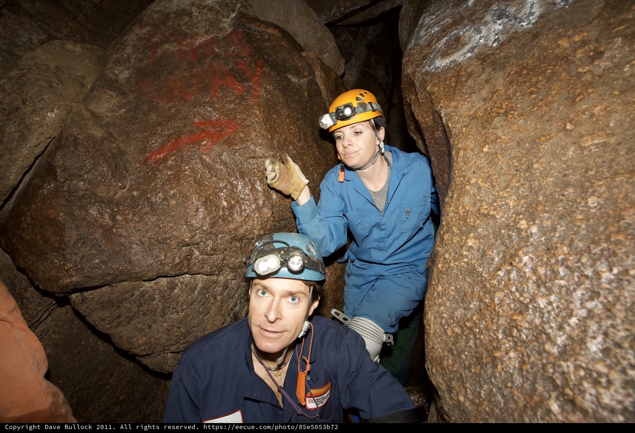 Cavers Exploring Ancient Rock Markings in Underground Cave