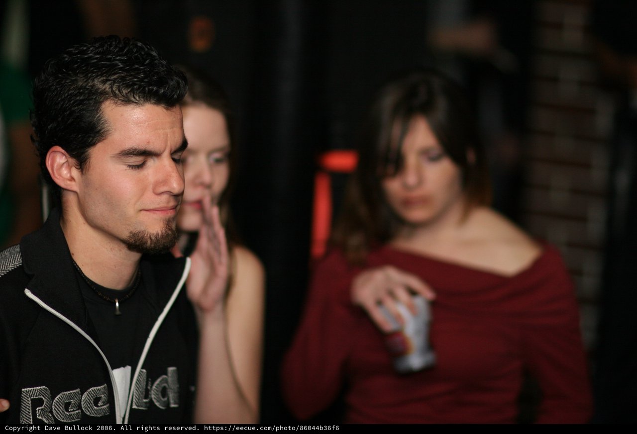 Young Man Lost in Thought at Nightclub Party