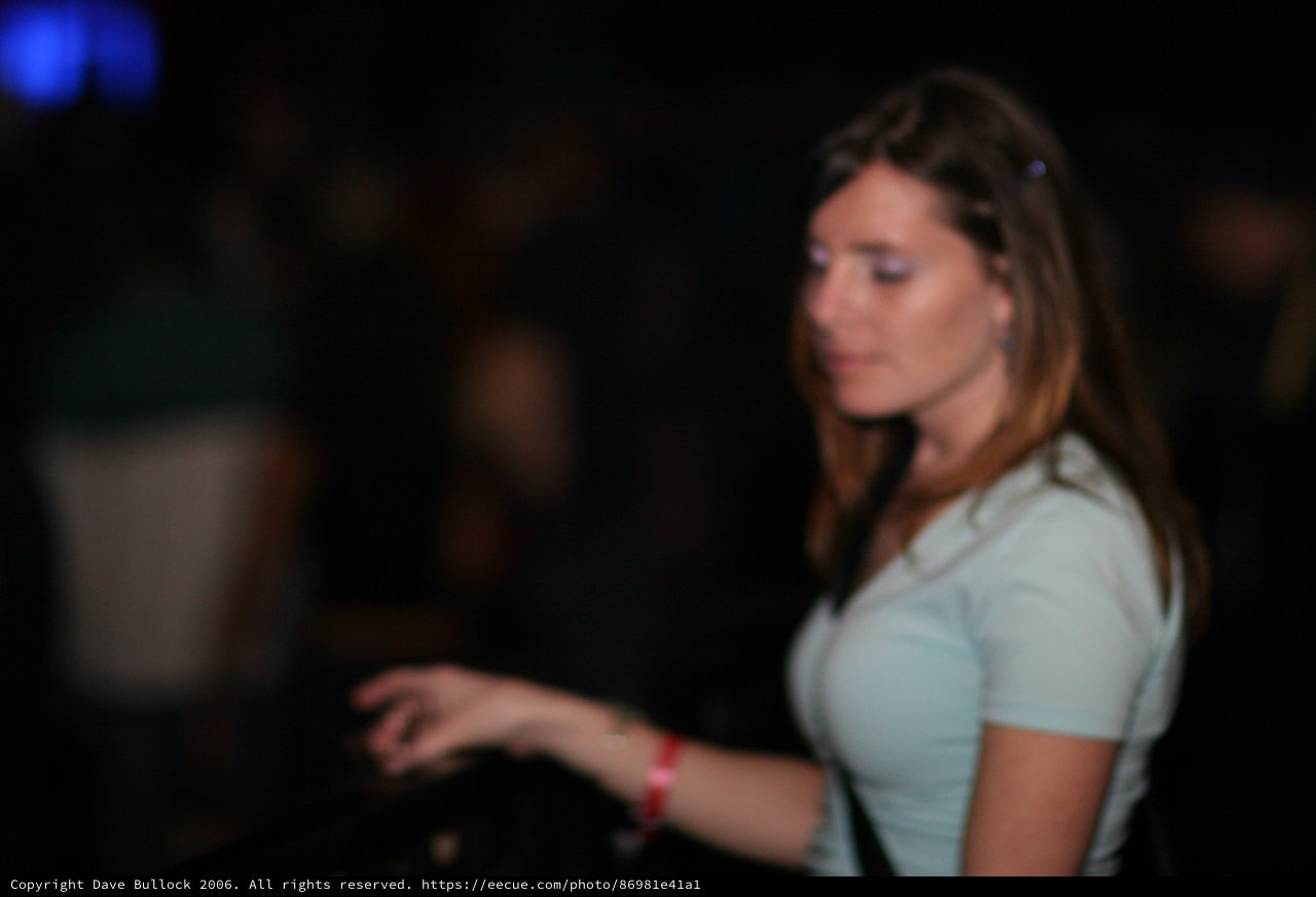 Woman in White Tee at Dimly Lit Nightclub