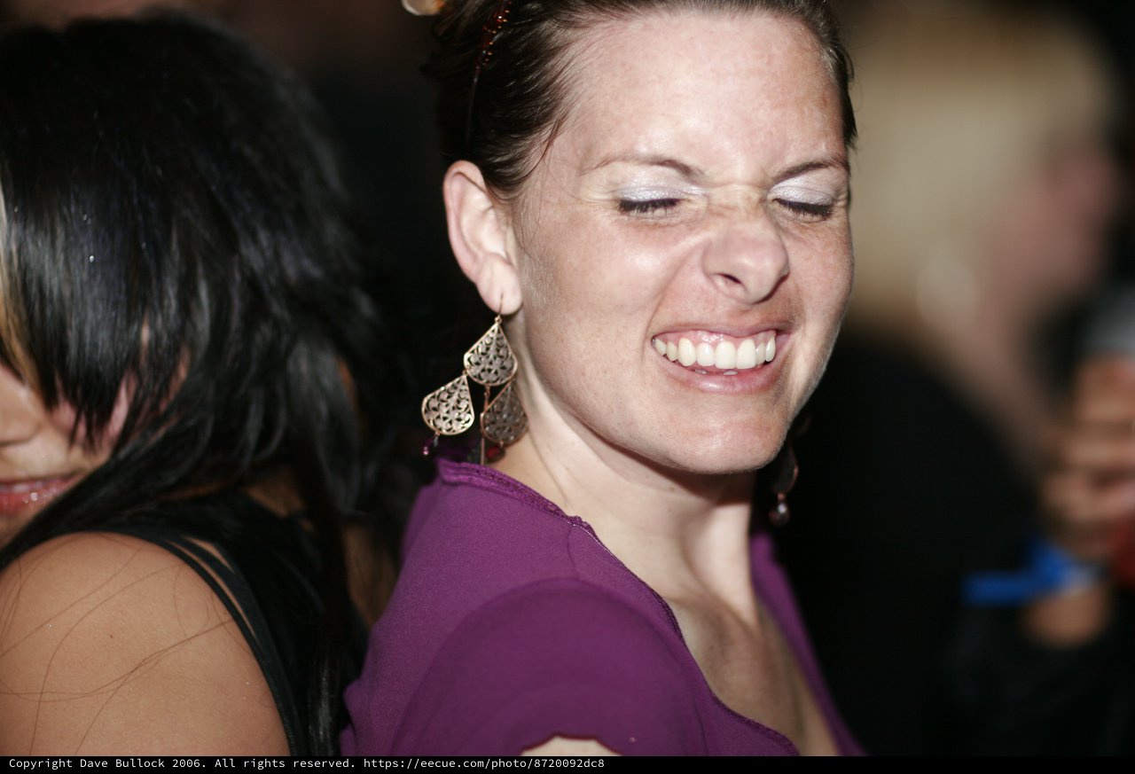 Joyful Woman Laughing at Nighttime Social Event