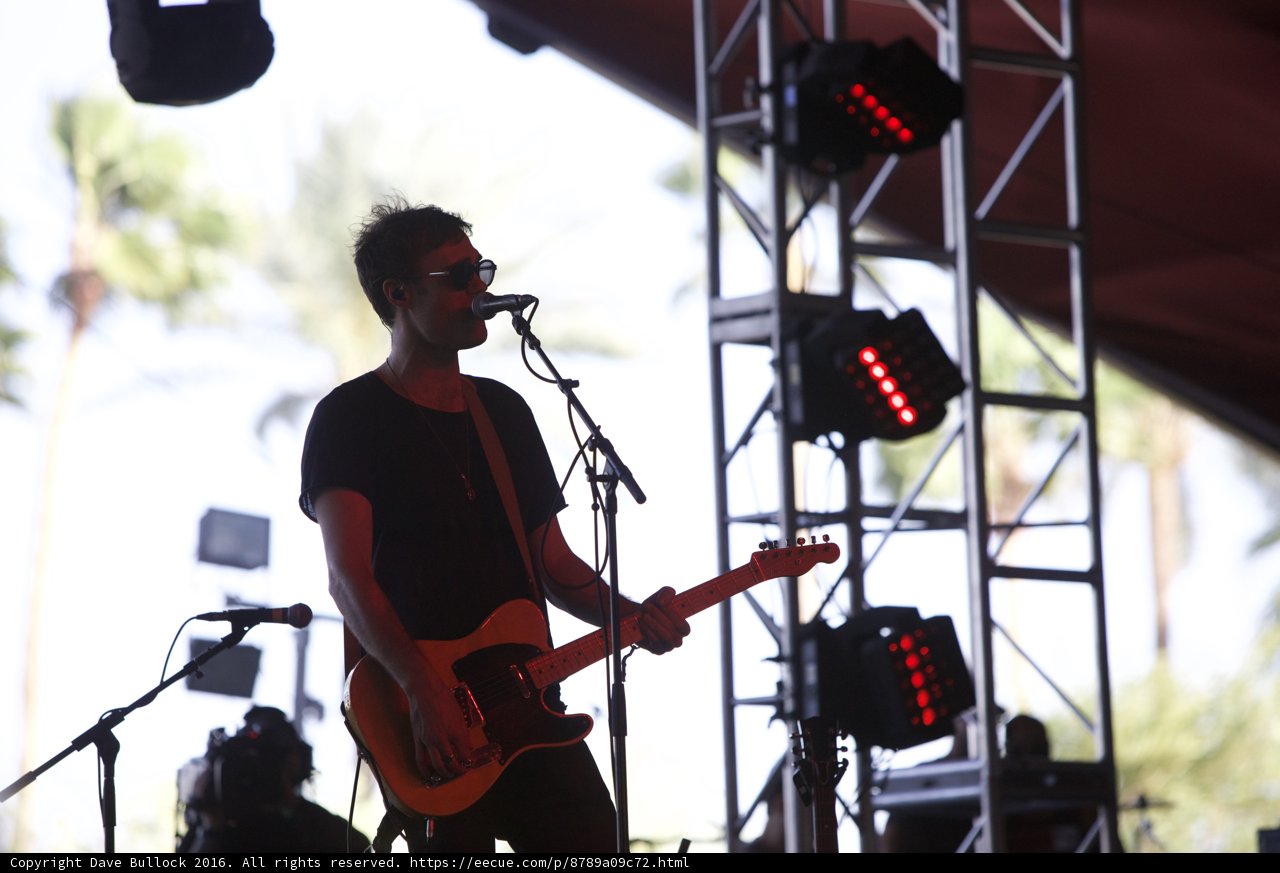 Man on stage with guitar and shades