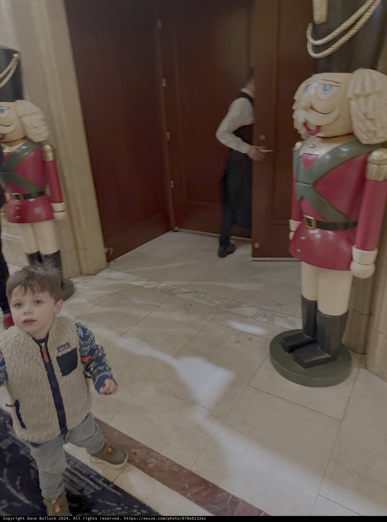Child Exploring Historic Building with Nutcracker Decorations