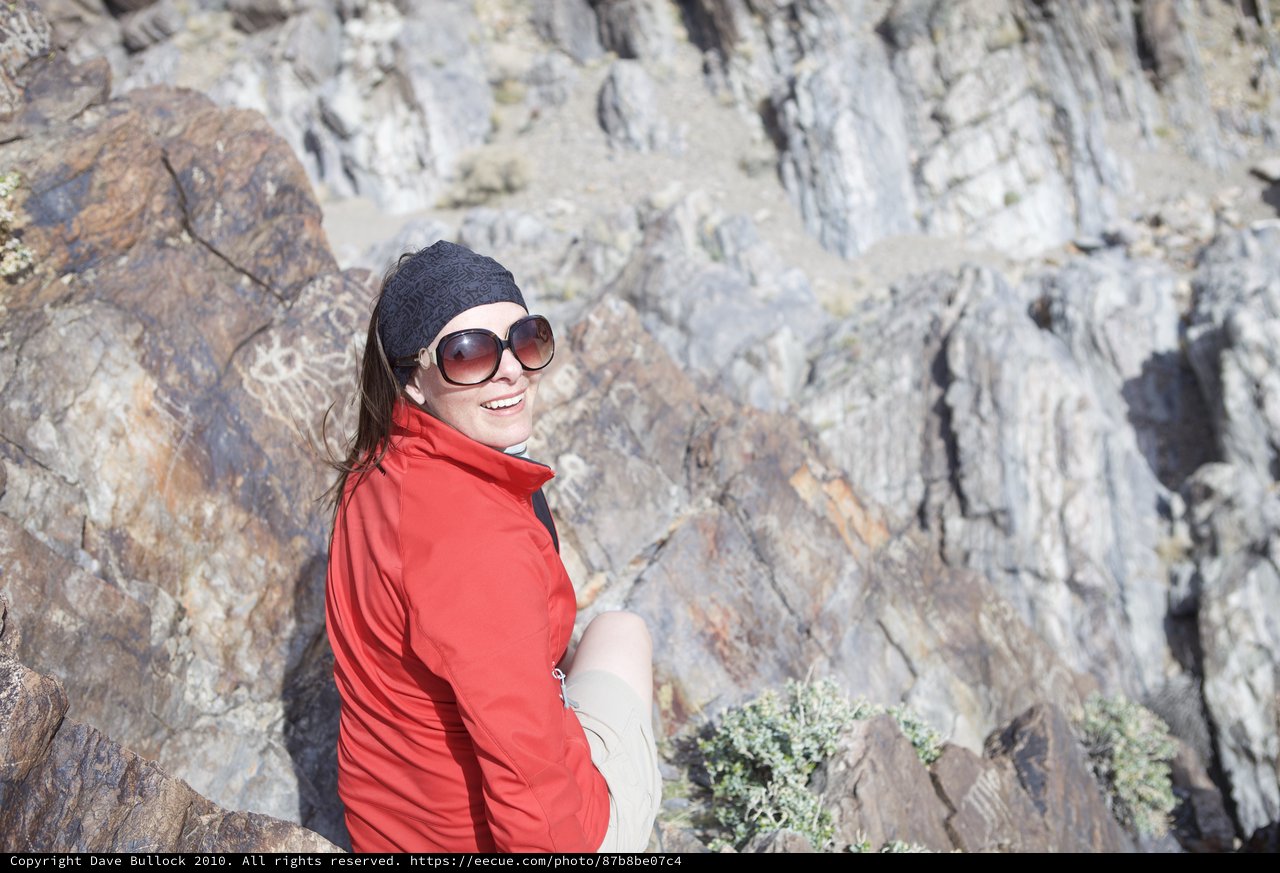 Smiling Hiker Pauses Against Ancient Desert Cliff Face
