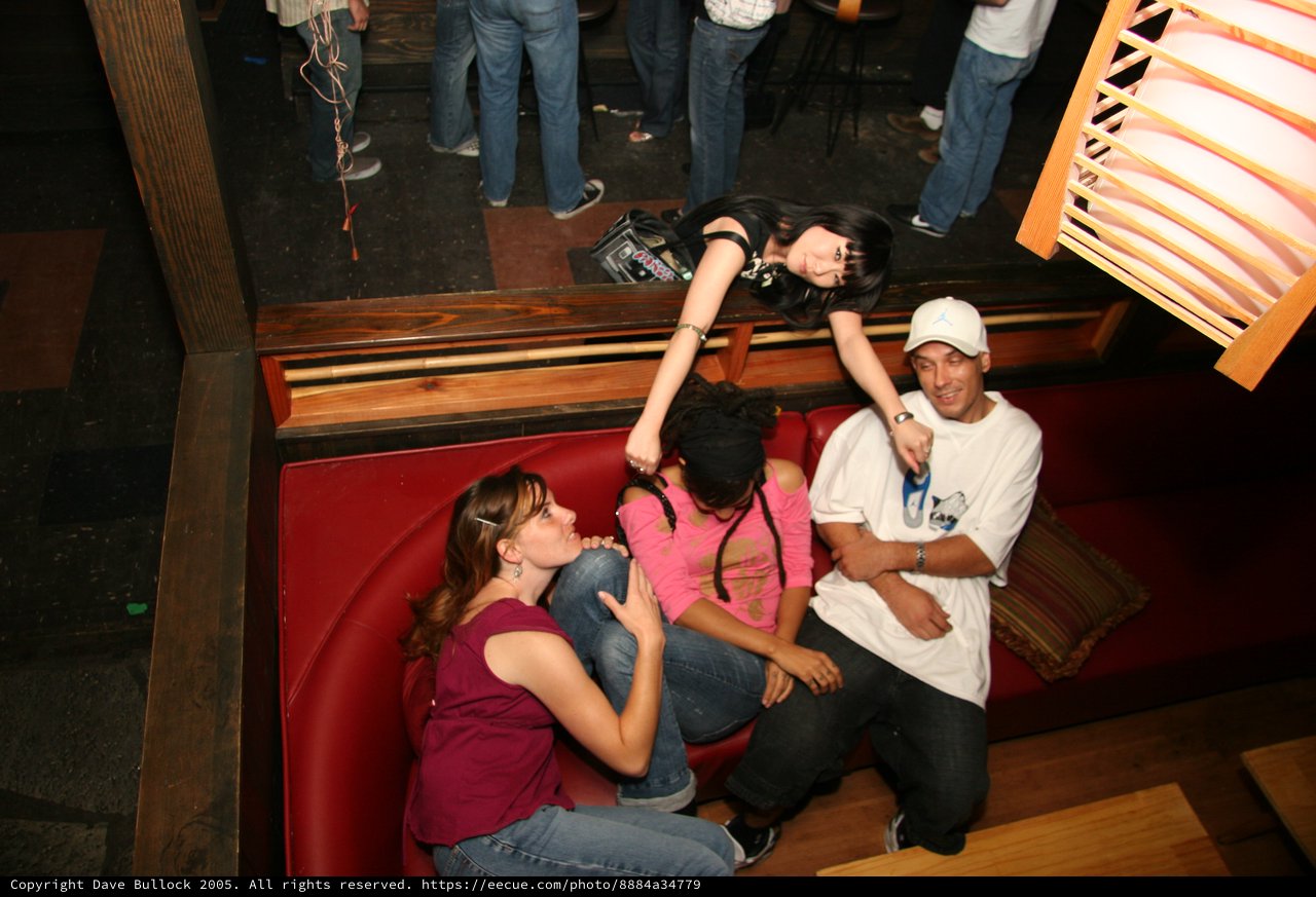 Friends Laughing Together at a Nightclub Booth