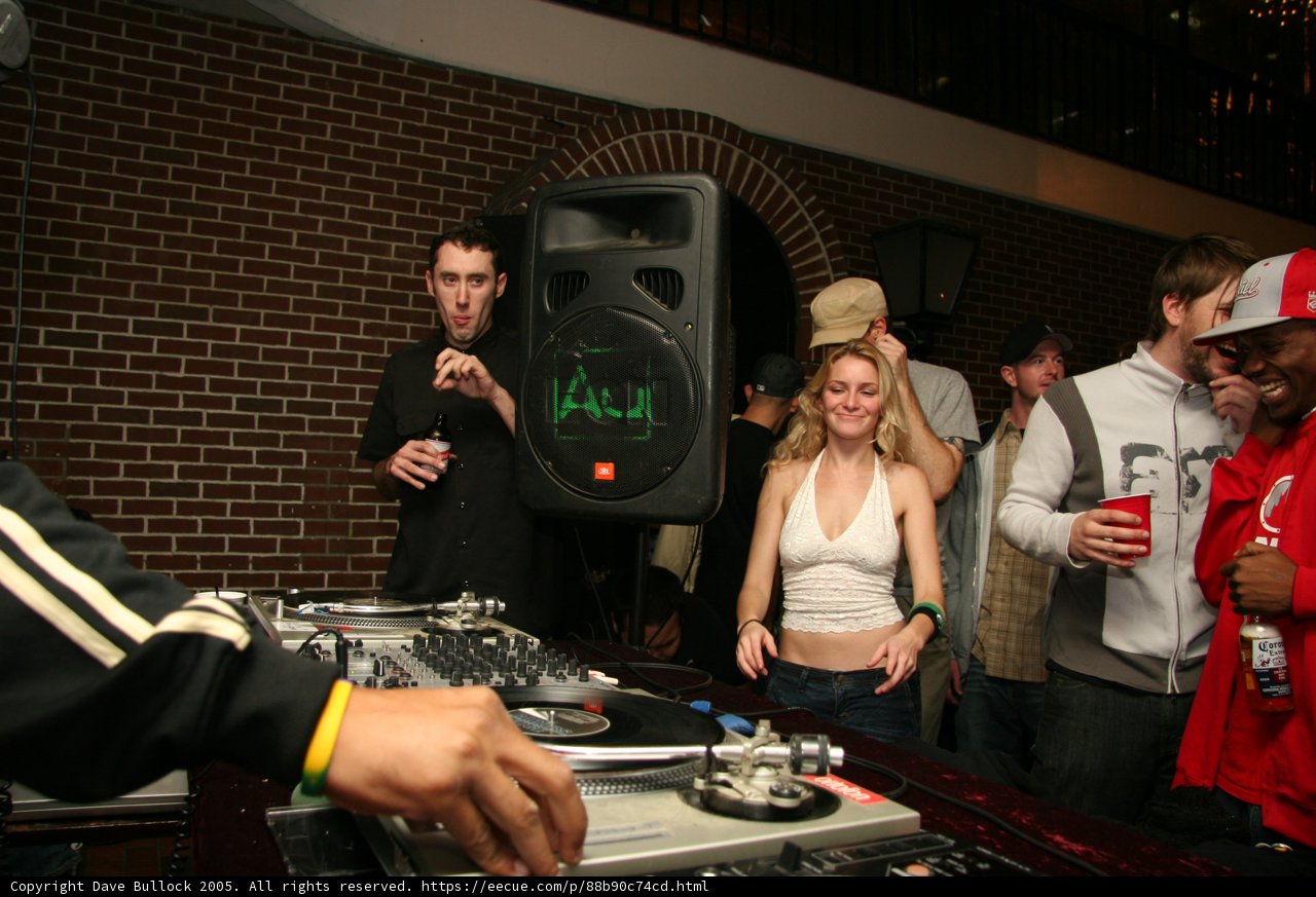 DJ in Black Jacket Spins Music at Nightclub