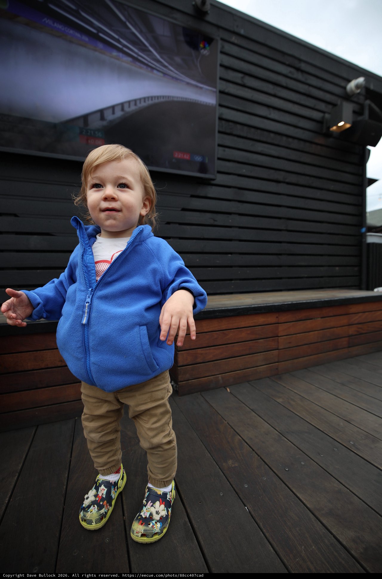 Toddler on Wooden Deck with Modern Building
