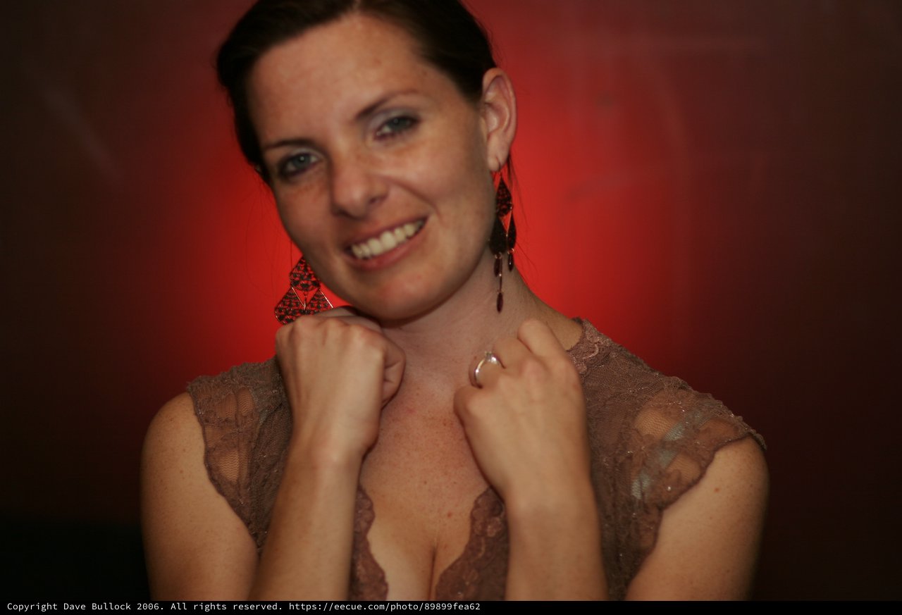 Smiling Woman in Lace Top Against Red Background