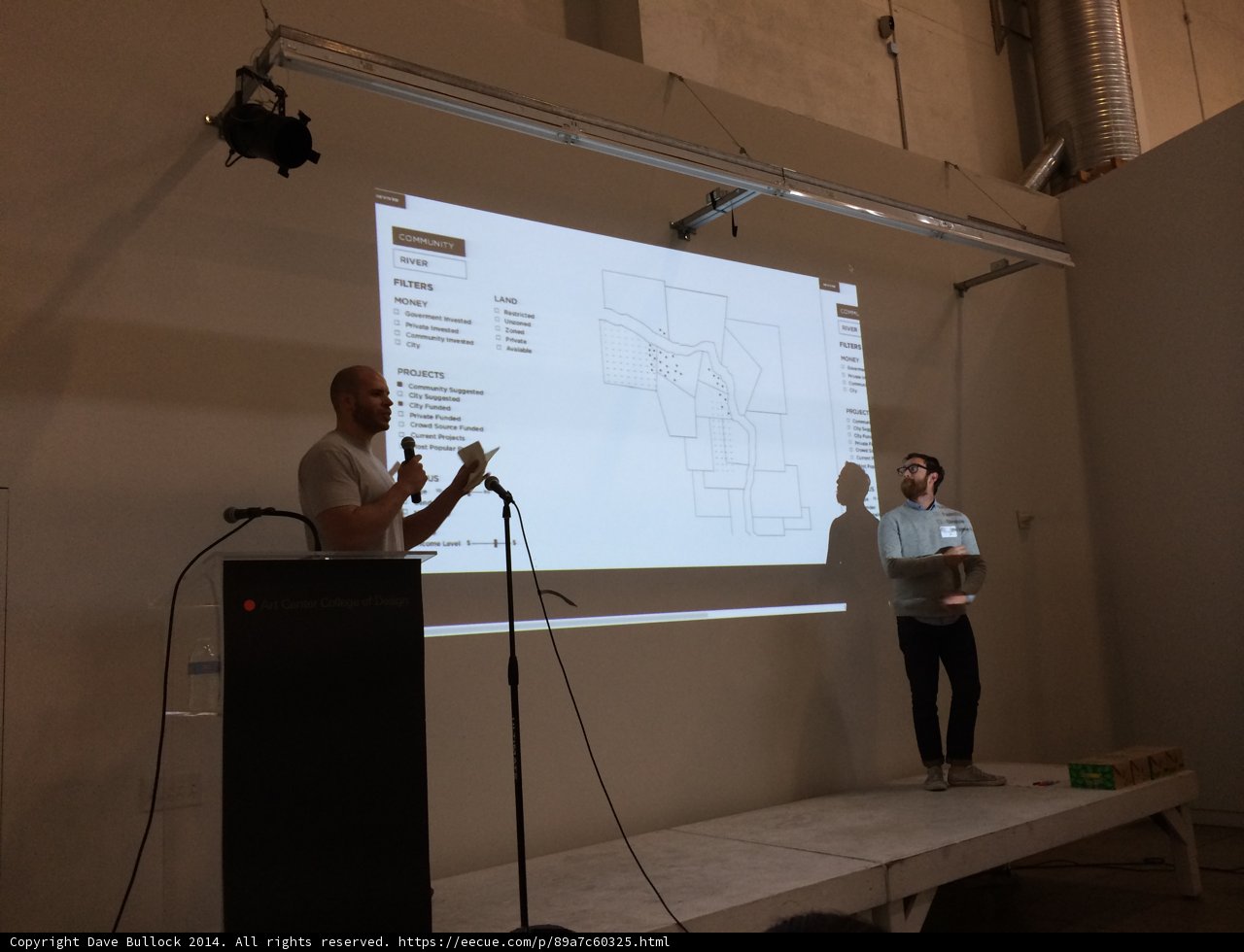 Two speakers presenting in front of a projection screen