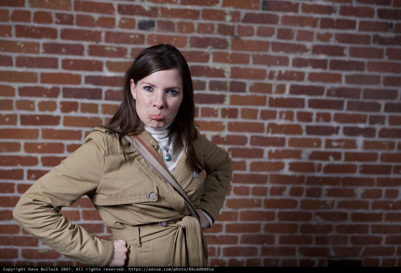 Defiant Woman Poses Against Urban Brick Wall