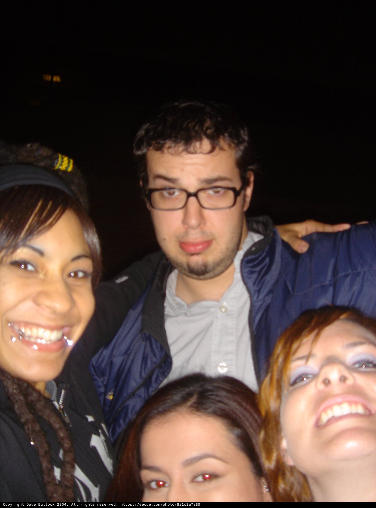 Friends Posing Together at a Nighttime Outdoor Event