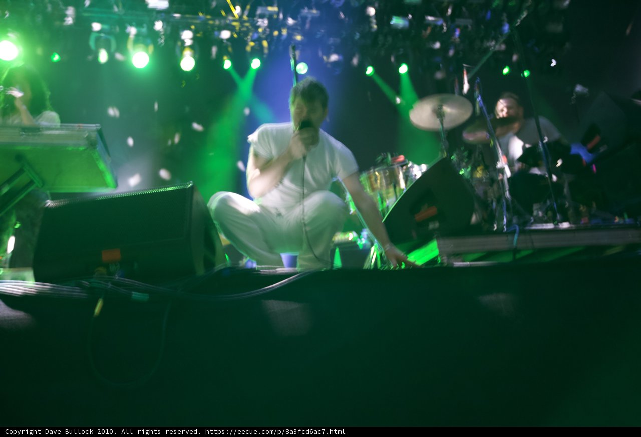 Live on Stage: Man in White with Musician Friends