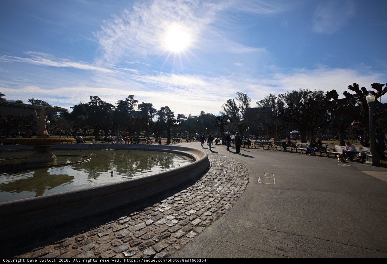 Sunlit Plaza with Fountain and Cobblestone Path