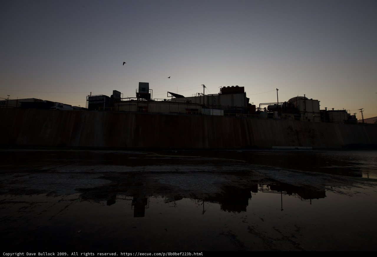A Factory at Sunset with Flock of Birds