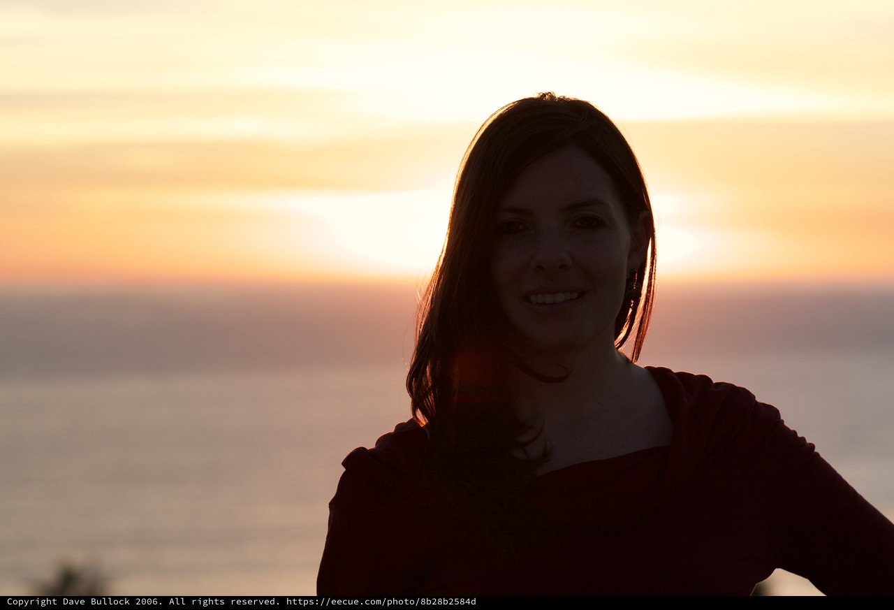 Smiling Woman Silhouetted Against Golden Sunset