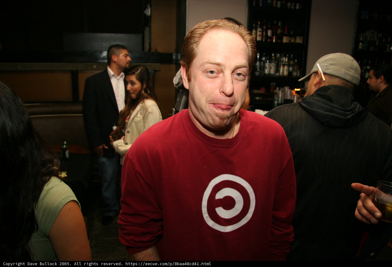 Man in Red Shirt Enjoying Drinks at Pub Party