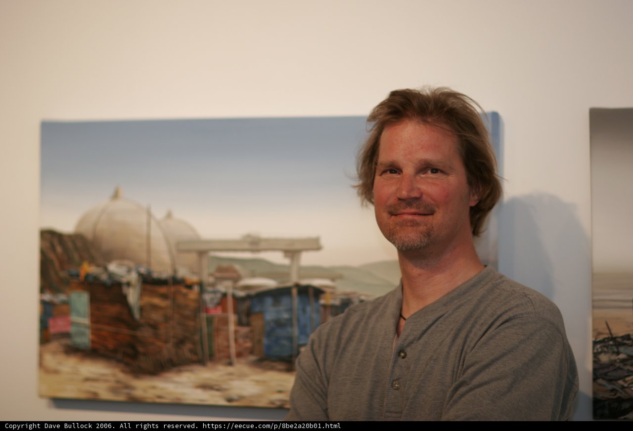 Man Contemplates Paintings in Art Gallery