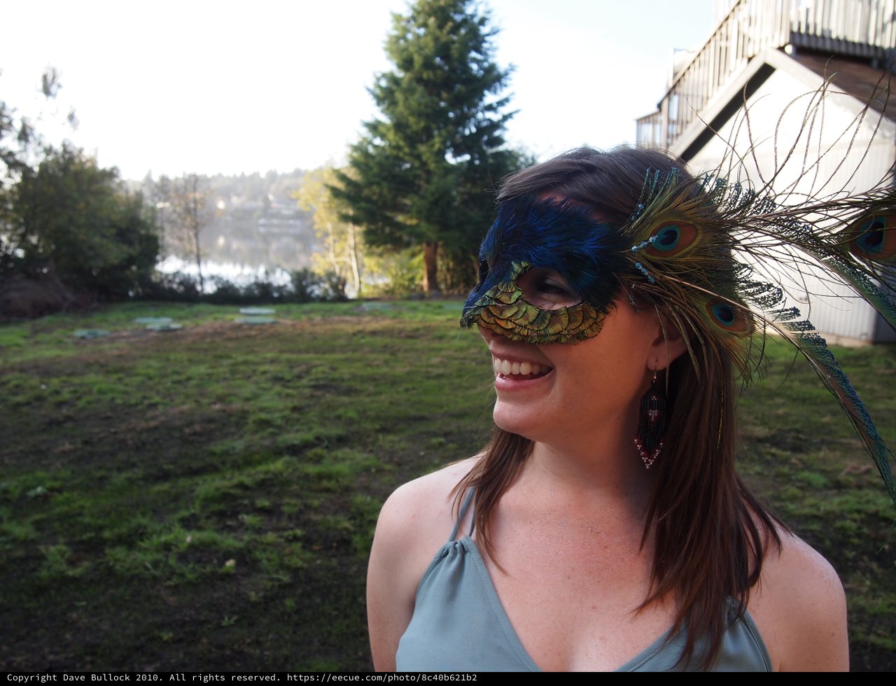 Smiling Woman in Peacock Feather Masquerade Mask