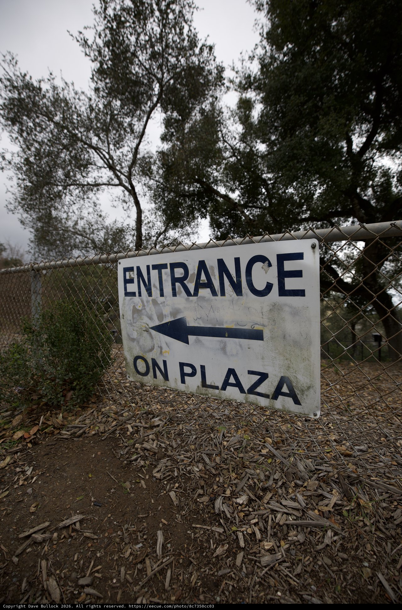 Weathered Entrance Sign Directing to Plaza