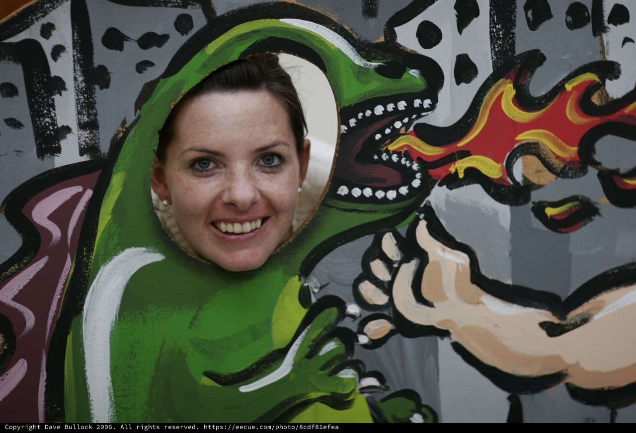 Woman Smiling Through Dragon Face Cutout Board