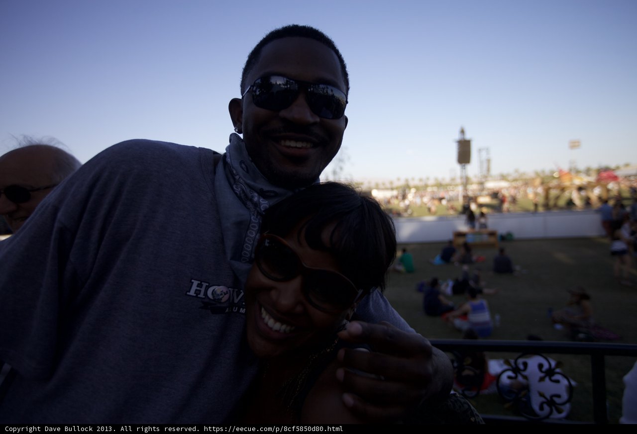 Smiling Duo Poses in Front of Stage at Coachella