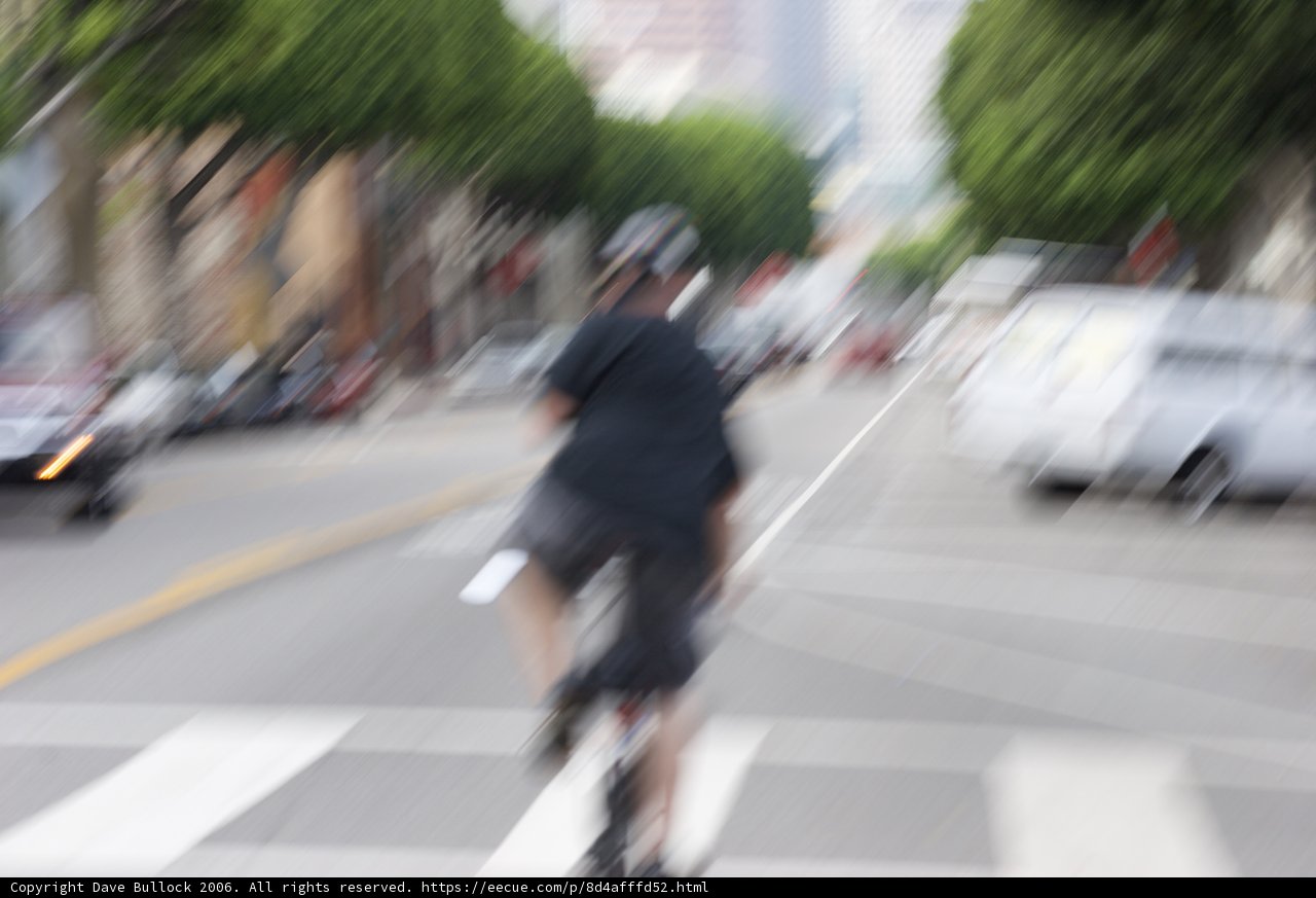 Blurred Cyclist on a Busy Road