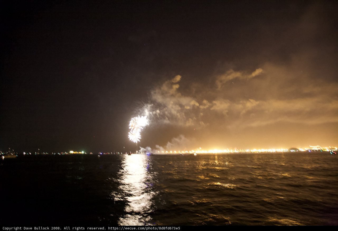 Glowing Flare amidst Night Skyline and Fireworks
