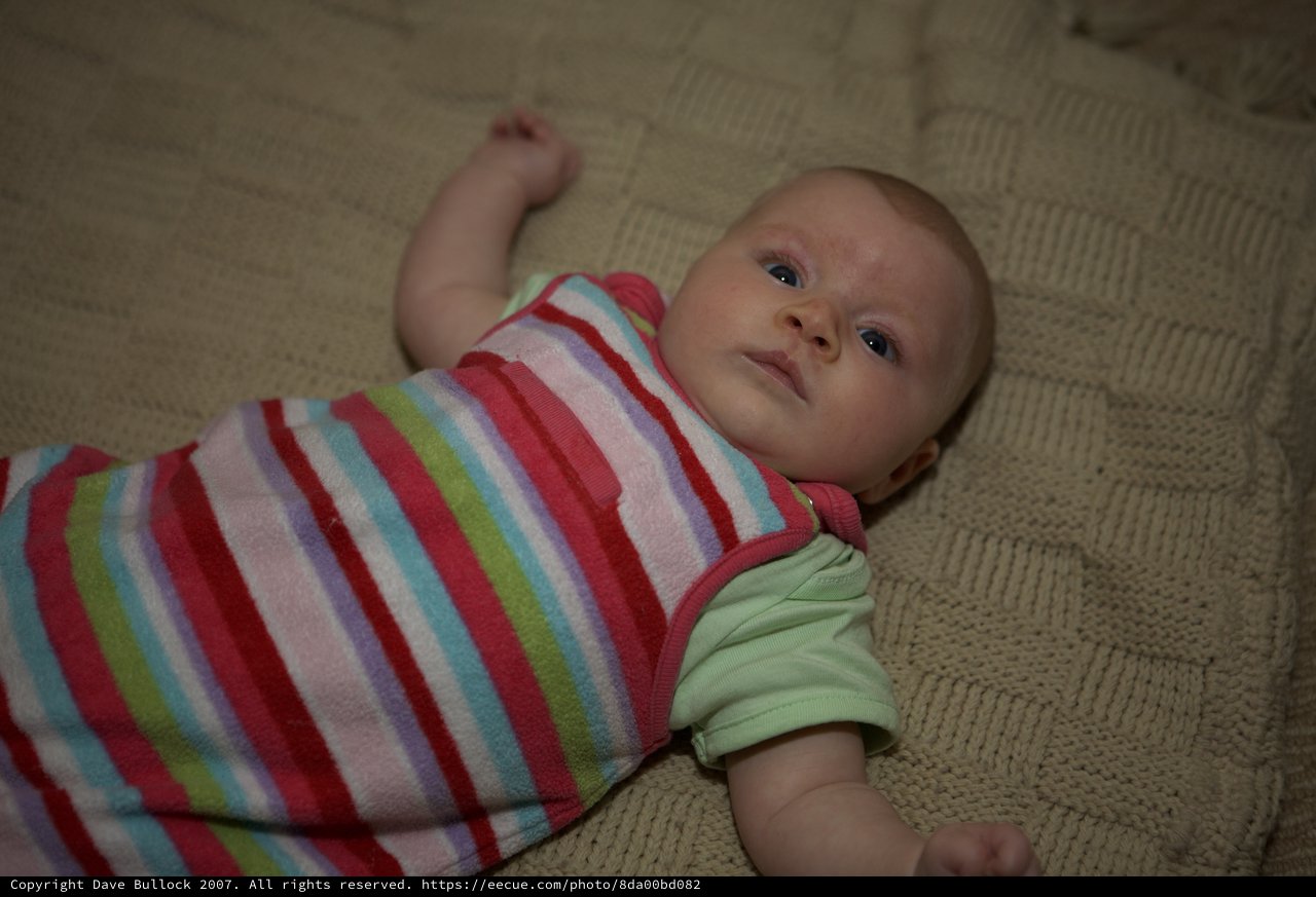 Curious Newborn Baby Lying on Knit Blanket