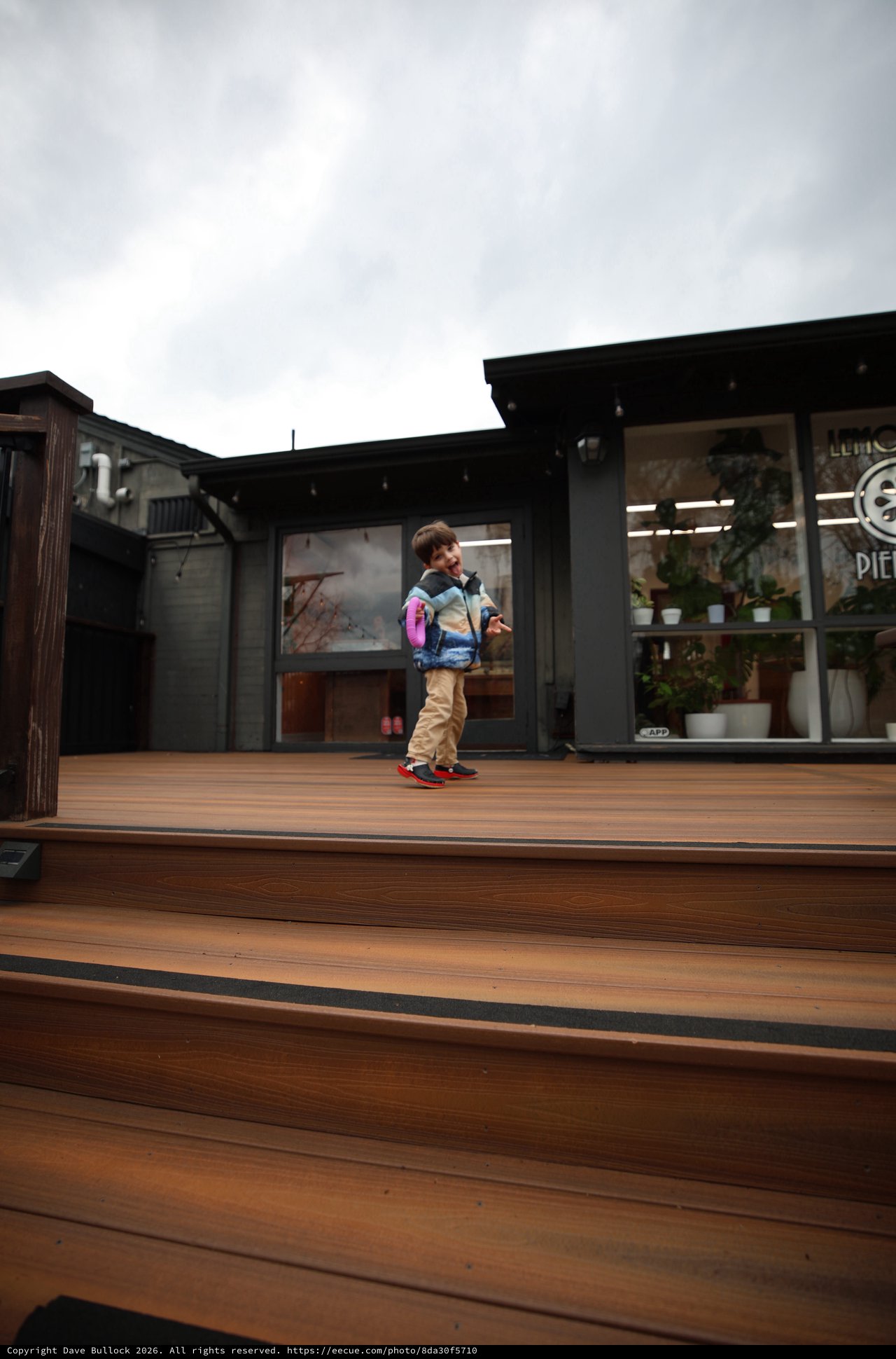 Child with Pink Backpack on Modern Wooden Deck