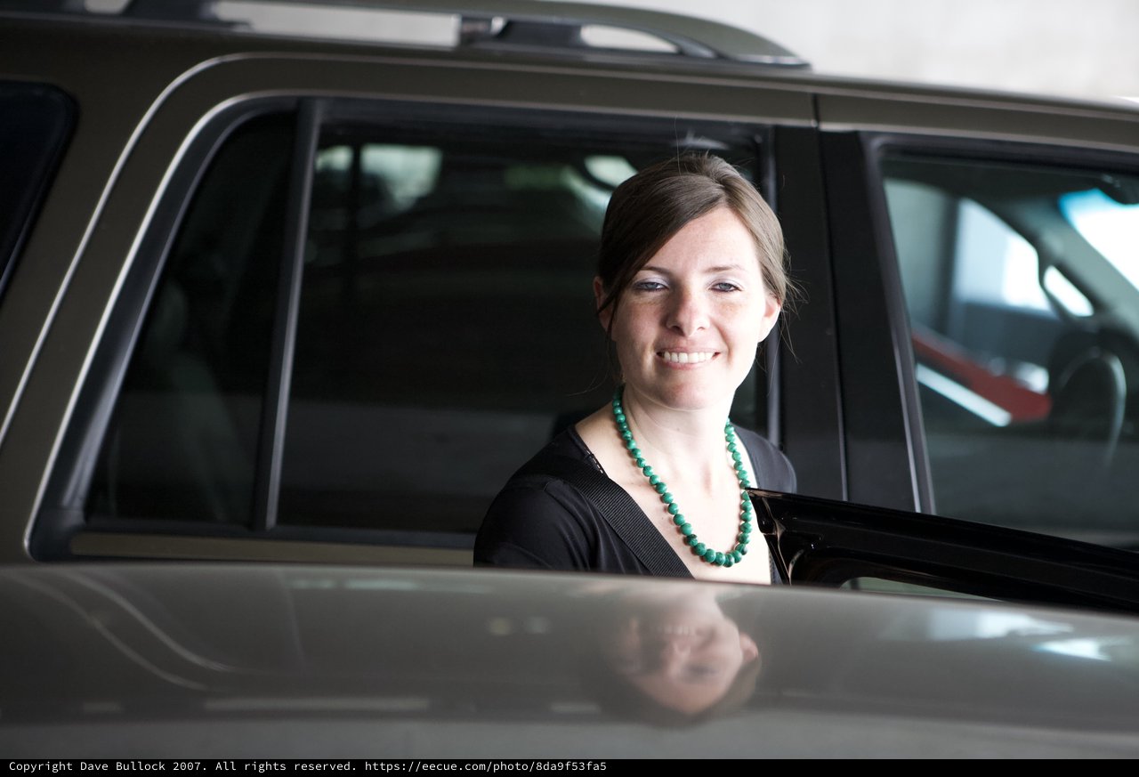 Smiling Woman Beside a Dark SUV Door