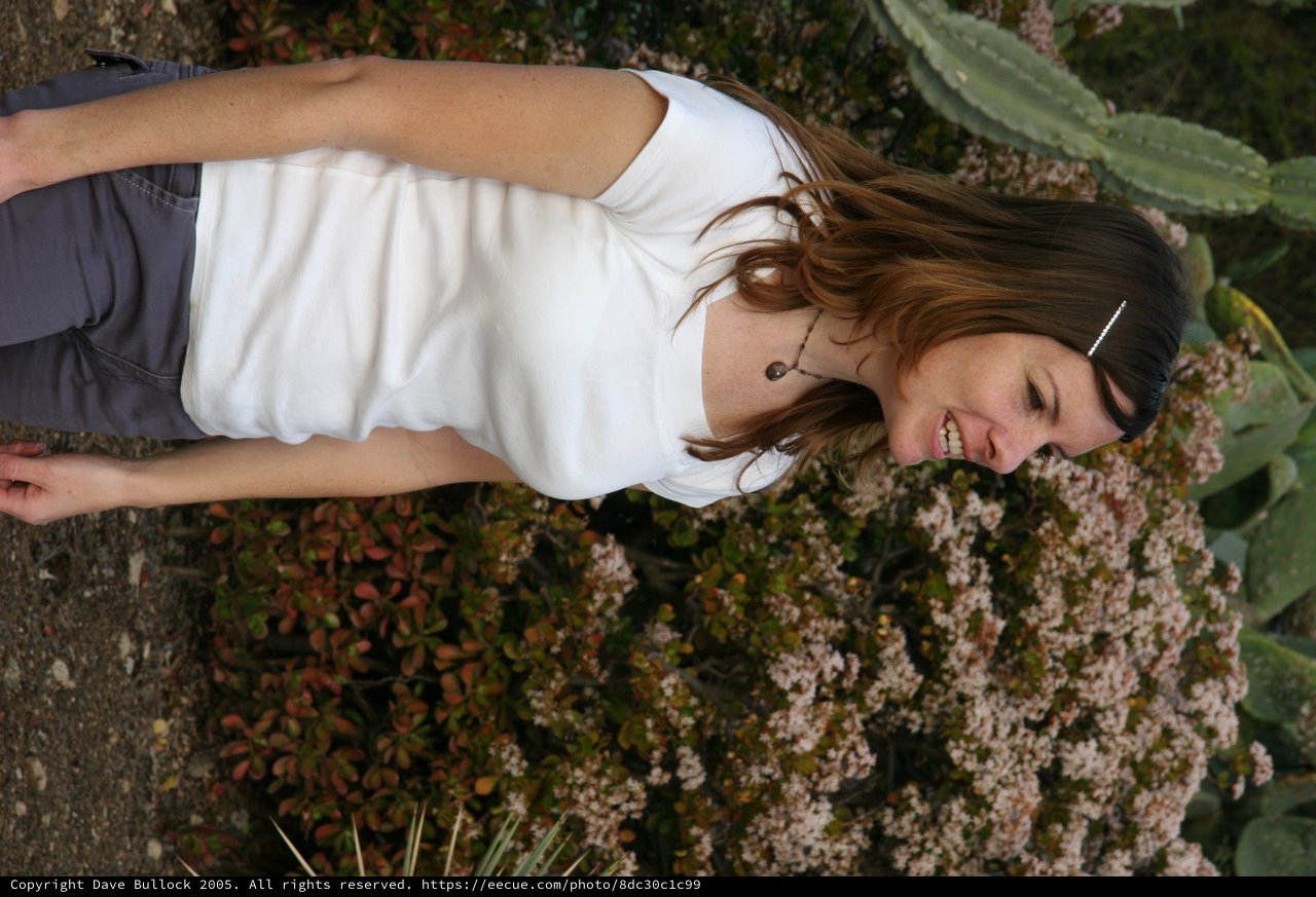 Smiling Woman in White Tee Among Desert Blooms